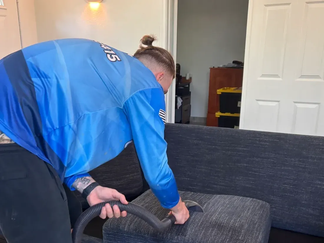 Technician extracting a fabric sofa cushion with an upholstery hand tool